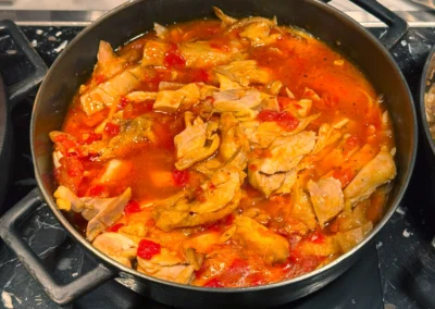 Braised chicken pieces in a tangy tomato-based sauce.