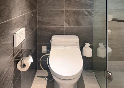 Bidet toilet room at Courtyard Taipei Downtown with modern dark tile walls and sleek design.
