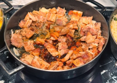 Black pepper pork belly sizzling in a hot pan.
