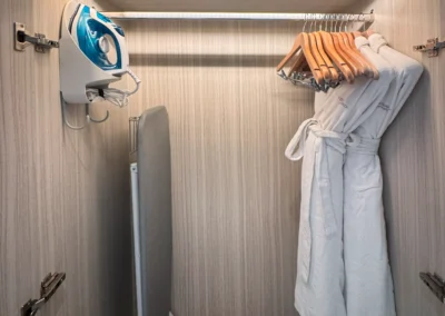 Hotel closet with ironing board, iron, hangers, and robes at Courtyard Taipei Downtown.