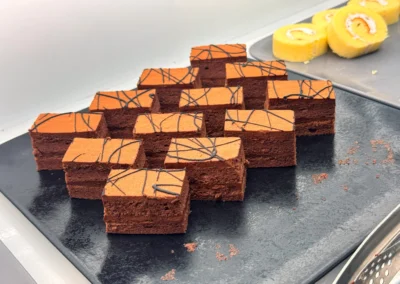 Chocolate sponge cake squares topped with chocolate drizzle.