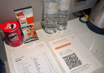 Mini bar snacks, water bottles, and in-room dining QR menu at Courtyard Taipei Downtown.