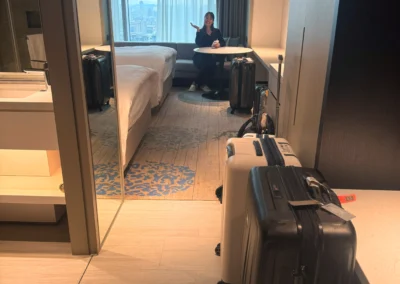 Twin room at Courtyard Taipei Downtown with a window seating area and view of the Taipei skyline, seen from the entry hallway.