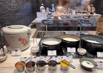 Oatmeal, soy bean milk, and congee station at MJ Kitchen with traditional toppings.