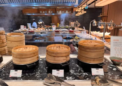A trio of bamboo steamers at MJ Kitchen filled with buns and dim sum.