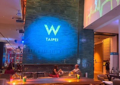 W Taipei logo illuminated on a wall inside the hotel.