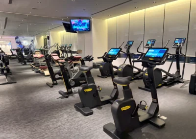 Cardio section in the FIT gym at W Taipei, featuring stationary bikes, ellipticals, and treadmills with interactive screens.