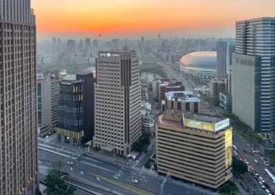 West-facing view from W Taipei hotel room at sunset, overlooking the city skyline and Taipei Dome.