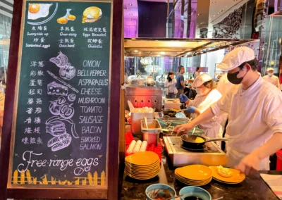 Live egg station at YEN restaurant in W Taipei's breakfast buffet, offering omelets, eggs Benedict, scrambled eggs, and various toppings like cheese, bacon, and smoked salmon.