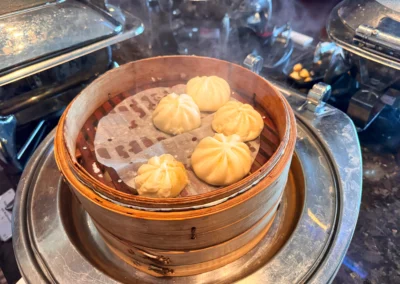 Steaming hot xiaolongbao (soup dumplings) served in a traditional bamboo steamer at YEN restaurant in W Taipei.